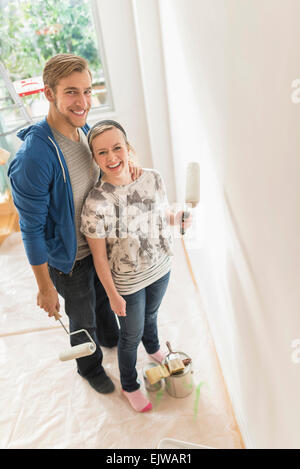 Portrait of smiling couple painting wall Stock Photo