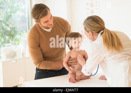 Small boy (2-3) with his father and female doctor in doctor's office Stock Photo