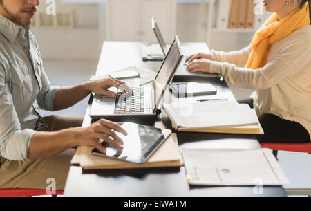 Close up of young man and woman working with laptops at desk Stock Photo
