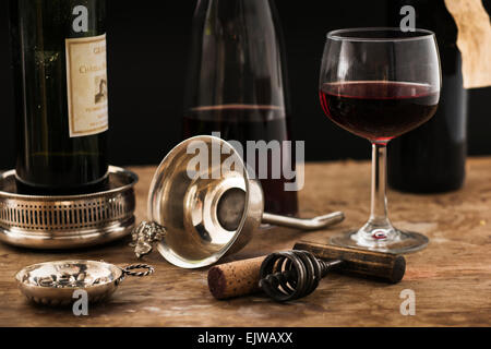 Still life with red wine glass, carafe and bottle on wooden table, studio shot Stock Photo