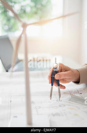 Close up of man's hands using compass while drawing plans Stock Photo