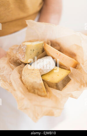 Close up of man's hand holding slices of cheese in paper Stock Photo