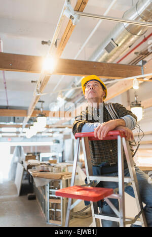 Electrician standing on step ladder Stock Photo