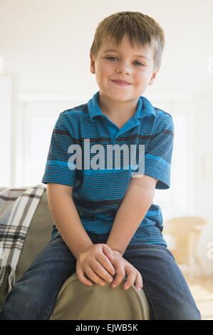 Portrait of boy (6-7) sitting on sofa Stock Photo