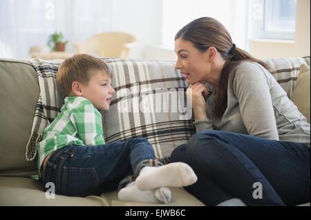 Mother and son (6-7) sitting on sofa Stock Photo