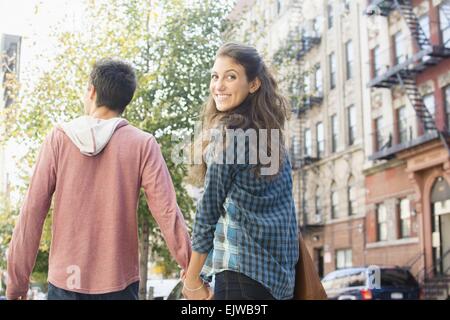 USA, New York State, New York City, Brooklyn, Young couple holding hands on sidewalk Stock Photo