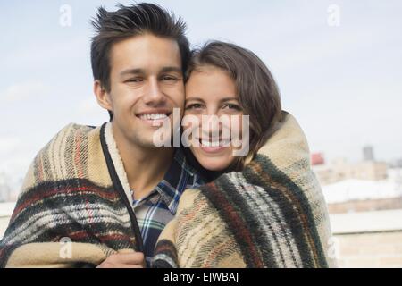 USA, New York State, New York City, Brooklyn, Portrait of young couple wrapped in blanket Stock Photo