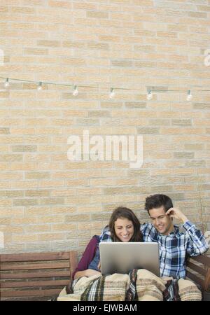 USA, New York State, New York City, Brooklyn, Young couple using laptop on roof