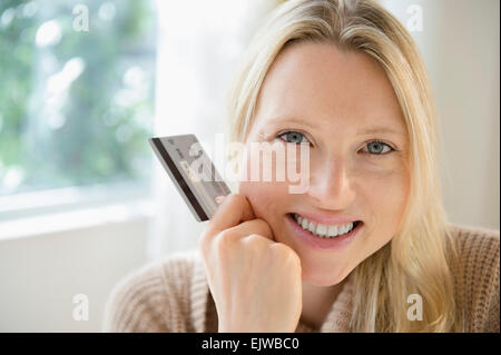 Portrait of woman holding credit card Stock Photo