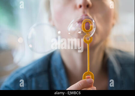 Woman blowing bubbles Stock Photo