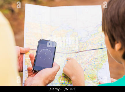 USA, Florida, Jupiter, Father and son (12-13) using smartphone app and map Stock Photo