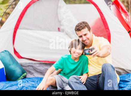 USA, Florida, Jupiter, Father and son (12-13) taking selfie in front of tent Stock Photo