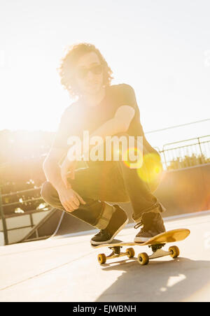 USA, Florida, West Palm Beach, Man crouching on skateboard Stock Photo