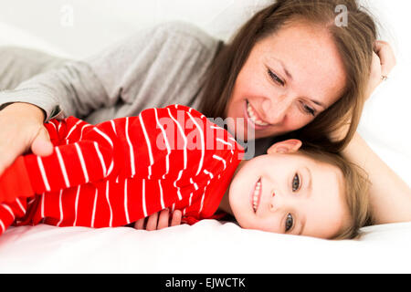 Mom and daughter (2-3) lying in bed Stock Photo