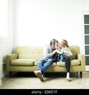 Family embracing on sofa Stock Photo