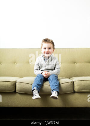Baby boy (2-3) sitting on sofa Stock Photo