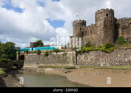 Arriva Trains Wales class 175 two coach dmu train passing Conwy castle. Stock Photo