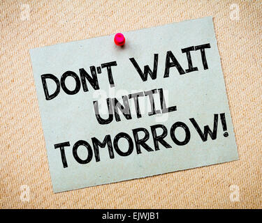 Recycled paper note pinned on cork board.Don't Wait Until Tomorrow Message. Motivational Concept Image Stock Photo