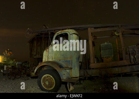 Antique tow truck in front of old barn on starry night Stock Photo