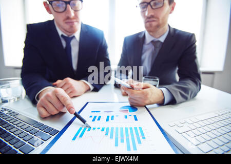 Close-up of businessmen analyzing chart at meeting Stock Photo