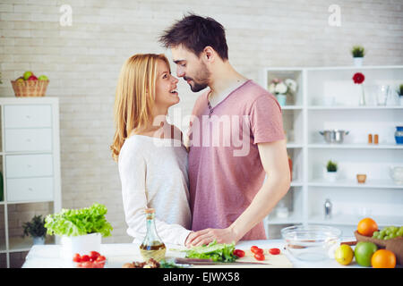 Happy young couple of vegetarians flirting in the kitchen Stock Photo
