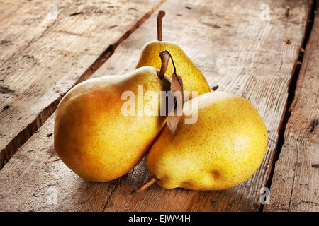 Three juicy ripe pears on a wooden background Stock Photo