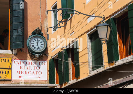 VENICE, ITALY - MAY 06, 2014: Clock and lantern hanging on a corner the house in Venice, Italy Stock Photo