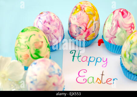 Hand painted decoupage Easter eggs on stands with a Happy Easter card in the middle Stock Photo