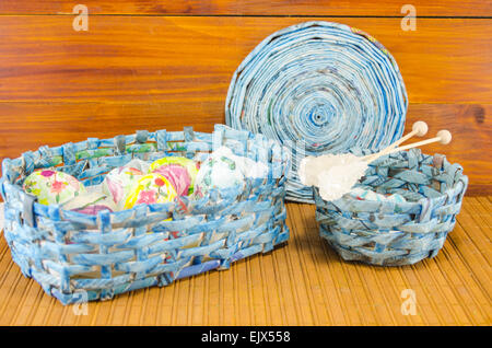 Blue basket full of hand colored Easter Eggs in decoupage against a wooden table Stock Photo