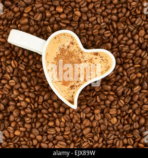 Filled cup on coffee beans Stock Photo