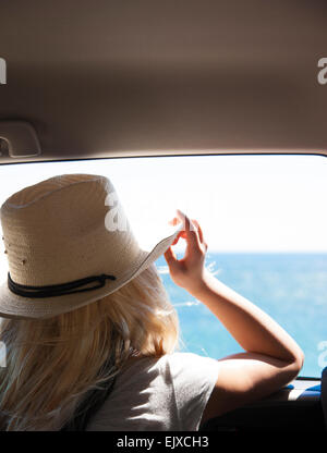 Back View of Woman Looking at the Ocean from Inside Car
