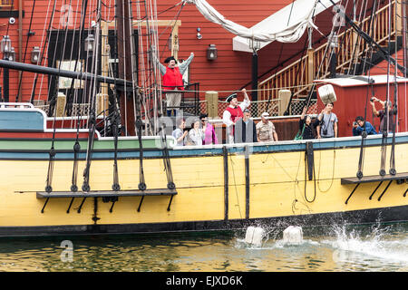 Tourists throwing tea chests from Beaver, replica of one of Boston Tea Party ships, Boston Tea Party Museum, Boston, USA Stock Photo