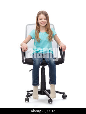 smiling little girl sitting in big office chair Stock Photo