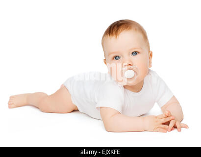 smiling baby lying on floor with dummy in mouth Stock Photo