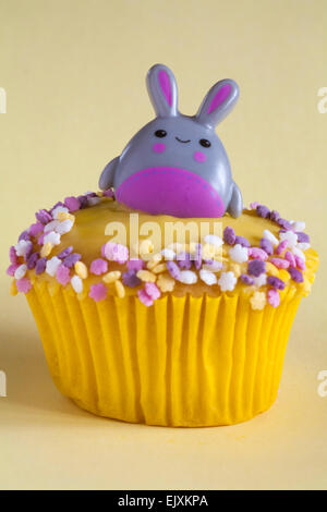 Easter bunny rabbit ring cupcake isolated on pale yellow background Stock Photo