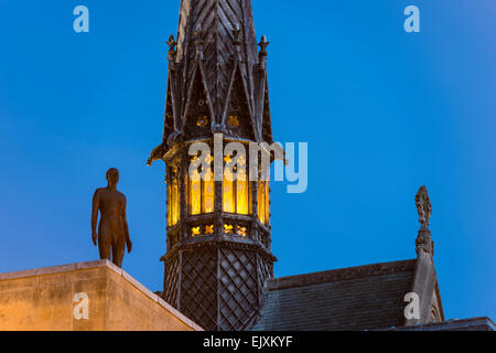 The spire of Exeter College chapel, Oxford University and Antony Gormley's sculpture The Iron Man at dusk Stock Photo
