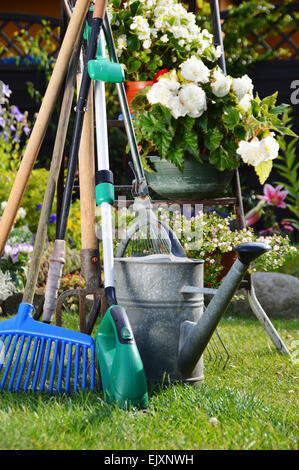 Watering can and tools in the garden Stock Photo