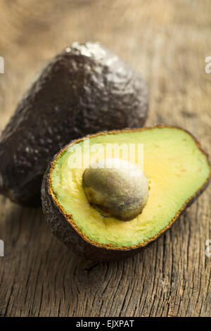 4 halved avocados sit on a cute cow-shaped wooden cutting board. A bowl of  fresh cucumbers sits in background. Dinner at home Stock Photo - Alamy