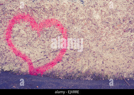 Red heart spray painted on wall in background Stock Photo