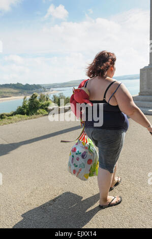 Young overweight woman enjoying summer sunshine by the sea. Stock Photo