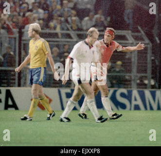 6 September 1989, Sweden v England. Terry Butcher organising the defence towards the end of Englands vital World Cup qualifier in Sweden, Butcher suffered a deep cut to his forehead early in the game but carried on after some impromptu stitches were inserted by the physiotherapist and his head swathed in bandages. His constant heading of the ball - unavoidable when playing in the centre of defence - disintegrated the bandages and reopened the cut to the extent that his white England shirt was entirely red by the end of the game. Stock Photo
