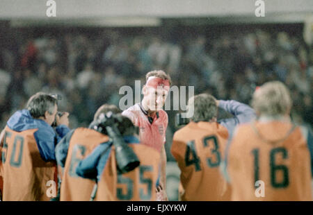 6 September 1989, Sweden v England. Terry Butcher being photograped by members of the press at the end of Englands vital World Cup qualifier in Sweden, Butcher suffered a deep cut to his forehead early in the game but carried on after some impromptu stitches were inserted by the physiotherapist and his head swathed in bandages. His constant heading of the ball - unavoidable when playing in the centre of defence - disintegrated the bandages and reopened the cut to the extent that his white England shirt was entirely red by the end of the game. Stock Photo