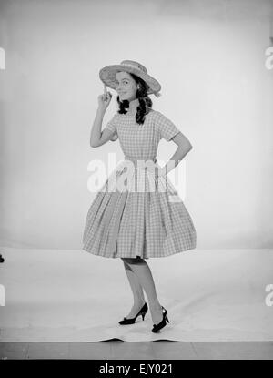 Model Jennifer Goddard. Brown-haired girl in checkered dress with pig ...