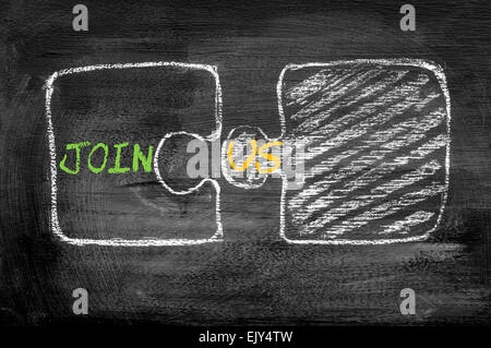 Puzzle Pieces joining together in Join Us words, isolated on black background. Chalk drawing on blackboard. Business Concept image. Stock Photo