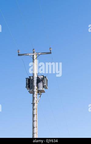 A 15kVA electrical transformer and power line covered with snow Stock Photo