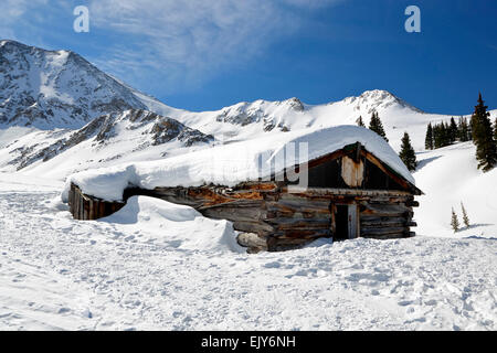 Snow-covered Ten-Mile Range and ruined log cabin, Boston Mine, Mayflower Gulch, near Copper Mountain, Colorado USA Stock Photo