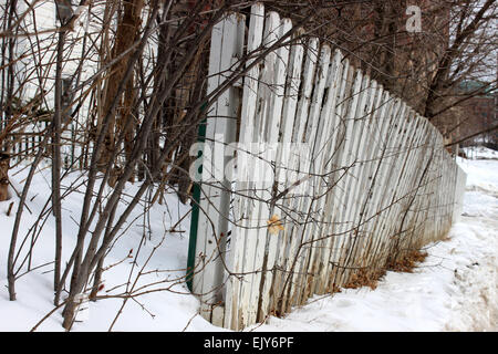 Detail of a white fence surrounded by trees in an abandoned house in the winter in Ontario, Canada Stock Photo
