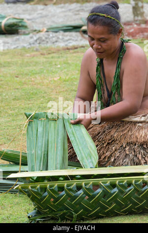 Yapese woman in traditional clothing weaving hand bag with palm tree leaves at Yap Day Festival, Yap Island, Federated States of Stock Photo