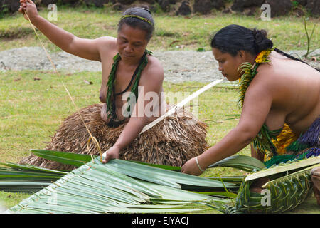 Yapese woman in traditional clothing weaving hand bag with palm tree leaves at Yap Day Festival, Yap Island, Federated States of Stock Photo