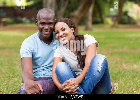 cute African American couple sitting on grass in the park Stock Photo